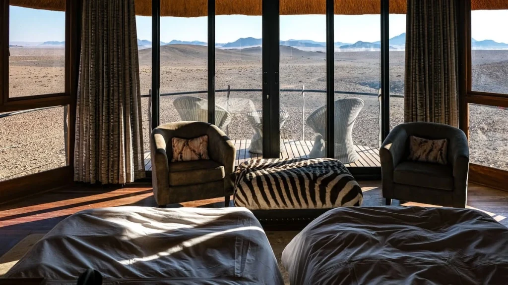 Vue panoramique sur le désert de Namibie depuis l'intérieur d'une chambre du Desert Hills Lodge.