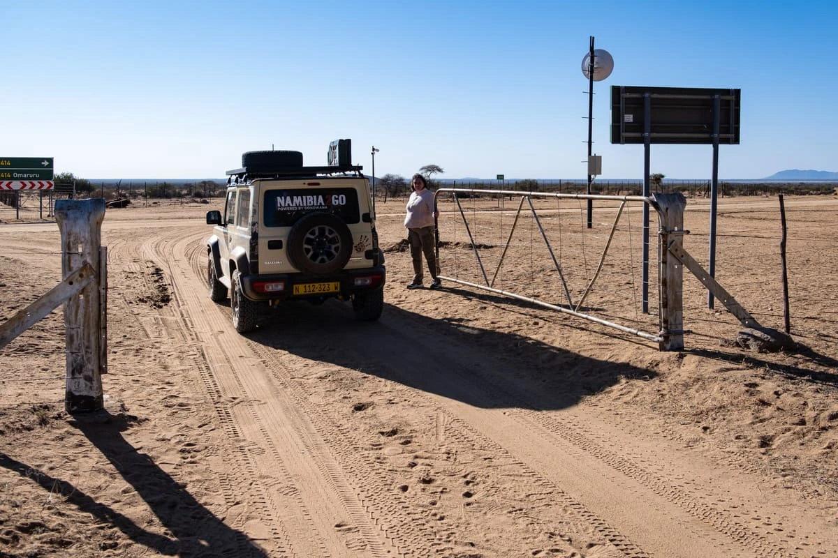 Suzuki Jimny franchissant une barrière sur une piste de sable en Namibie