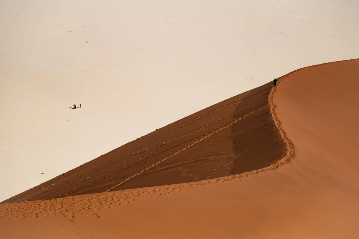 Rencontre entre le désert de sel blanc et les dunes de sable rouge à Sossusvlei, l'un des paysages les plus célèbres de Namibie.