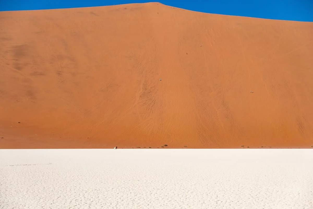 Le contraste spectaculaire entre le sable rouge du désert du Namib et la cuvette de sel blanche à Sossusvlei.