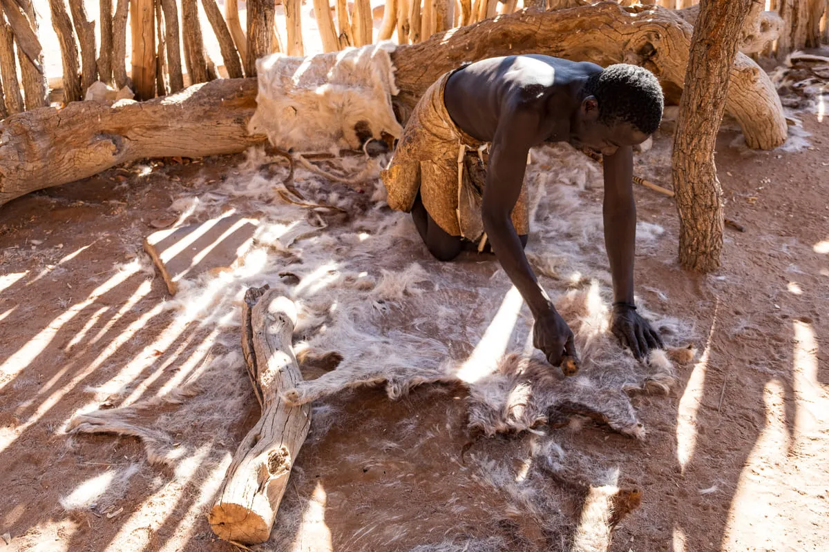 Démonstration du travail traditionnel du cuir par un homme au Damara Living Museum en Namibie.