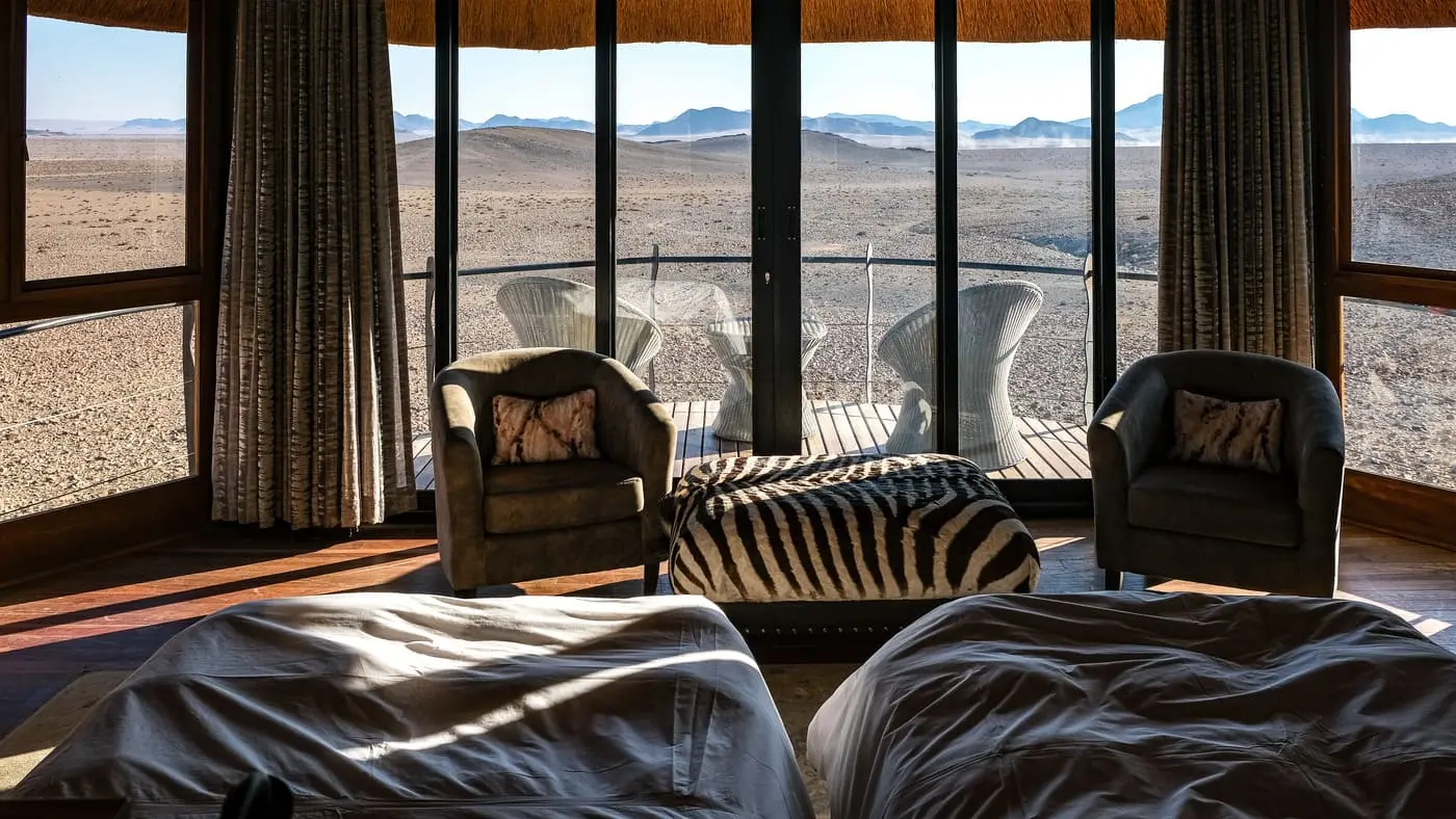 L'intérieur confortable d'une chambre au Desert Hills Lodge avec vue étendue sur la plaine minérale et lunaire à Sesriem en Namibie