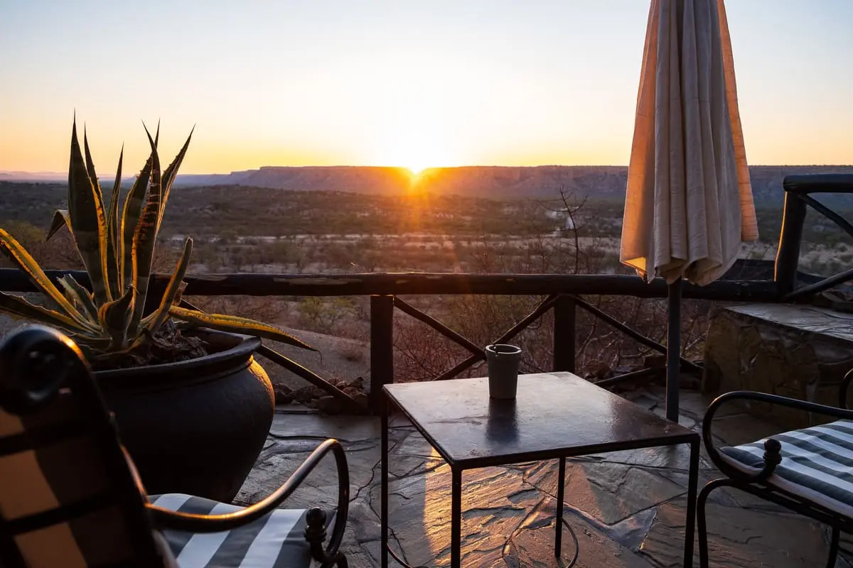 vue sur le lever de soleil depuis la terrasse d'une chambre du Vingerklip Lodge en Namibie