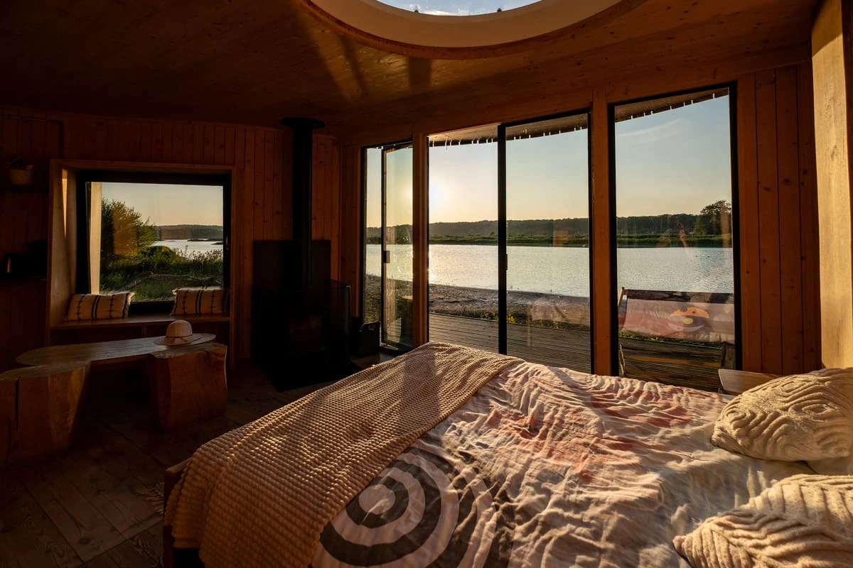 Intérieur de la cabane de l'Aquascope de Virelles avec vue sur le lac à travers les grandes baies vitrées