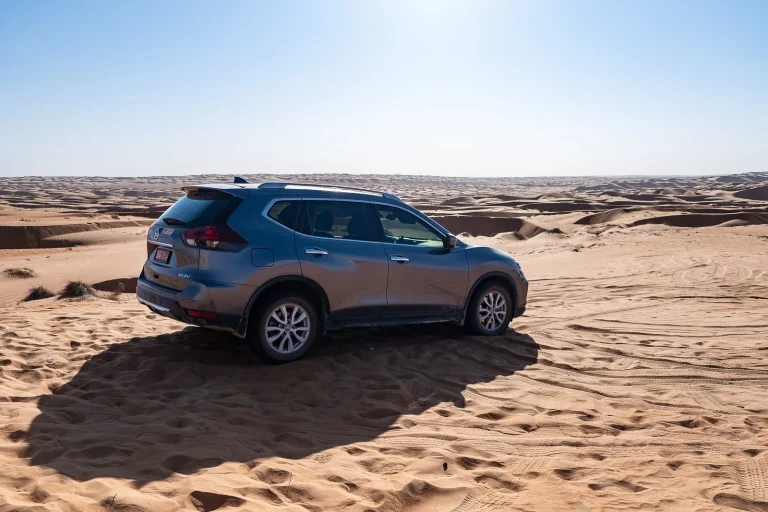 Un Nissan X-Trail garé dans les dunes du désert de Wahiba Sands à Oman.